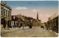 Ulica s vežou kostola, ozdobená zástavami, Lučenec (1905)